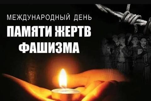 Международный день памяти жертв фашизма. Свеча на руках. Тёмный фон. Справа вверху колючая проволка